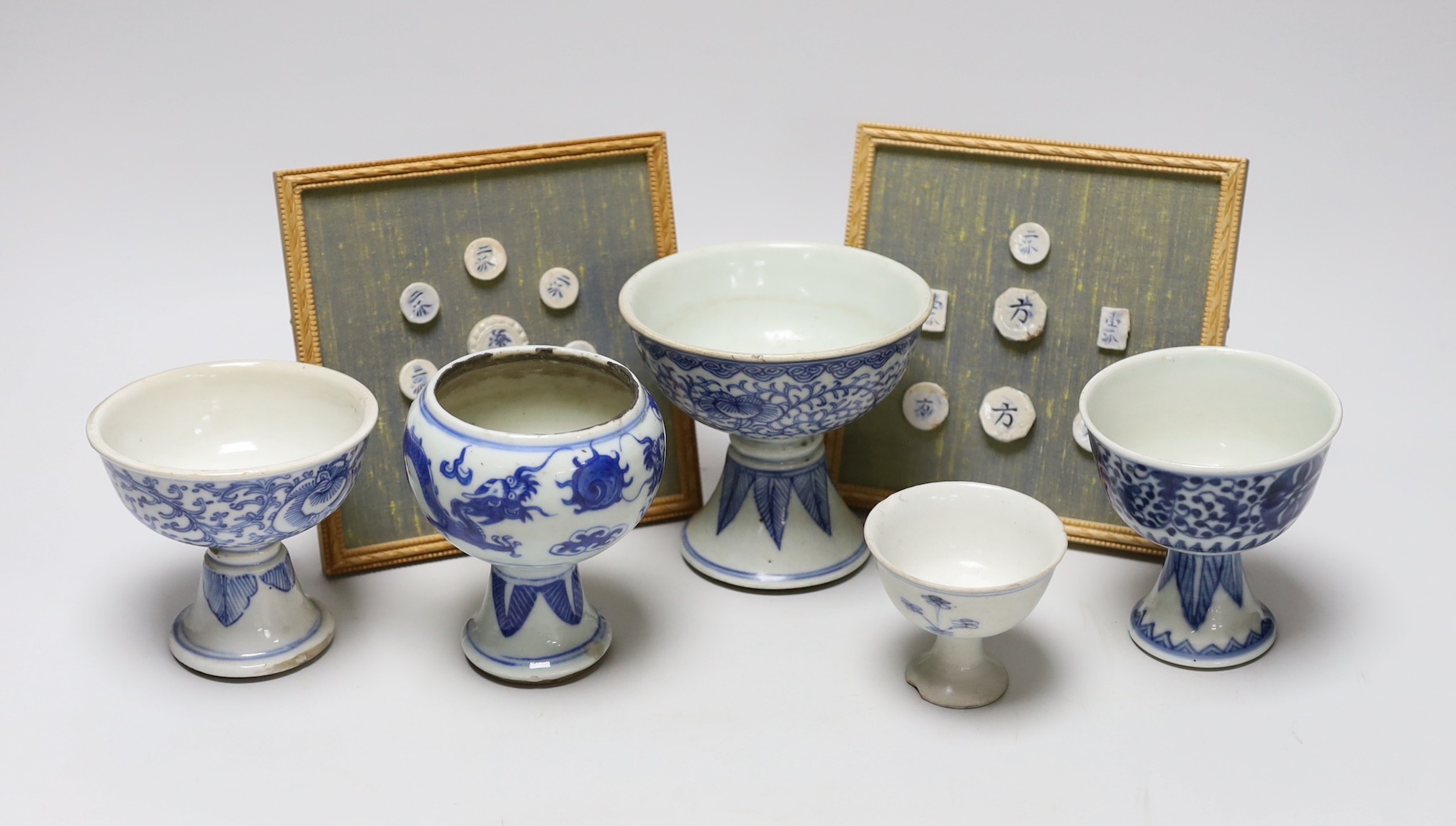Five 19th century Chinese blue and white stem cups and two framed sets of Thai gaming counters, tallest cup 11cm